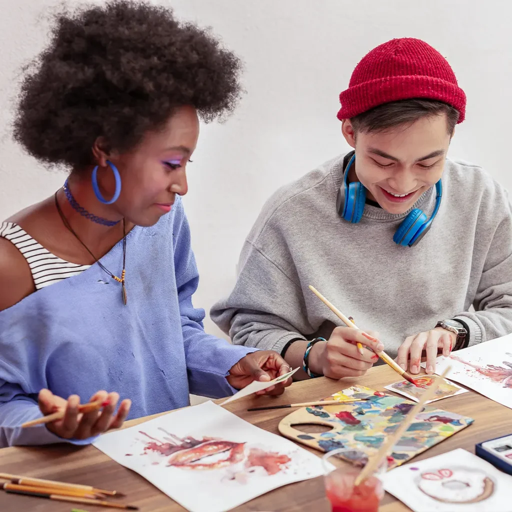 two teenagers painting together at a table ABA services massachusetts